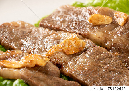 国産黒毛和牛カルビ焼肉。サンチュの上に盛り付け(にんにくチップのせ)。 国産黒毛和牛カルビ焼肉。サンチュの上に盛り付け(にんにくチップのせ)。 73150645