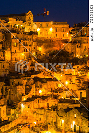 イタリア ライトアップされたマテーラの洞窟住居とマテーラ大聖堂の写真素材