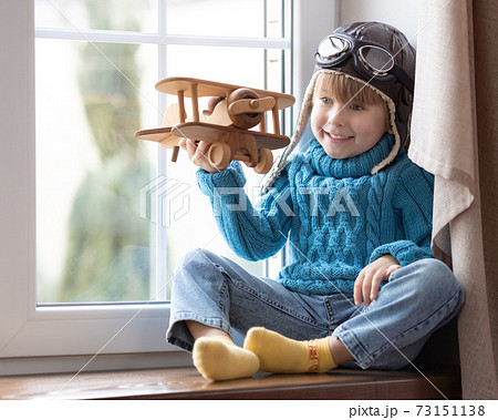 Happy child playing with toy airplane at home Happy child playing with toy airplane at home 73151138