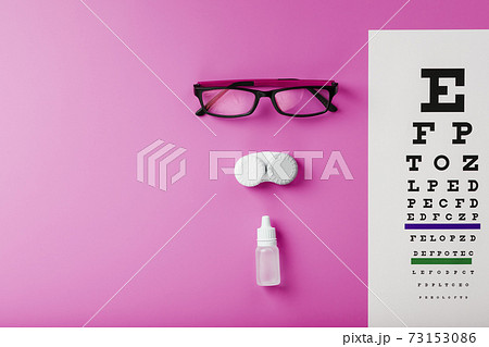 Ophthalmologist accessories glasses, lenses and vitamins with a test target for vision correction on a pink background. Ophthalmologist accessories glasses, lenses and vitamins with a test target for vision correction on a pink background. 73153086
