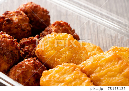 テイクアウトイメージ。透明プラスチック容器に入れられた、チキンナゲットと肉団子の唐揚げ。 テイクアウトイメージ。透明プラスチック容器に入れられた、チキンナゲットと肉団子の唐揚げ。 73153125