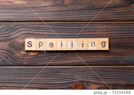 spelling word written on wood block. spelling text on cement table for your desing, concept spelling word written on wood block. spelling text on cement table for your desing, concept 73154109