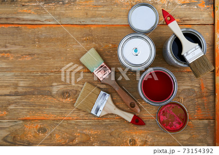 Paint cans and brushes on the old wooden background. Paint cans and brushes on the old wooden background. 73154392