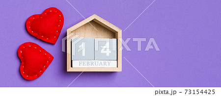Top view of wooden calendar and textile hearts on colorful background. The fourteenth of February. Valentine's day concept 73154425