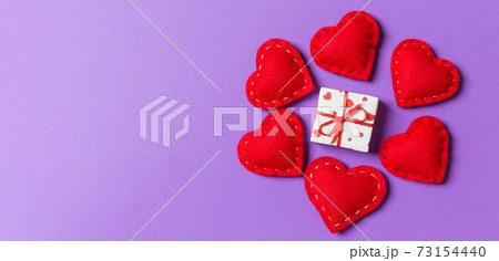 Holiday composition of gift boxes and red textile hearts on colorful background with empty space for your design. Top view of Valentine's Day concept Holiday composition of gift boxes and red textile hearts on colorful background with empty space for your design. Top view of Valentine's Day concept 73154440