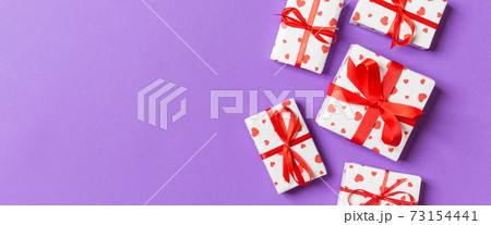 Top view colorful valentine background made of gift boxes with red hearts. Valentine's Day concept with copy space 73154441