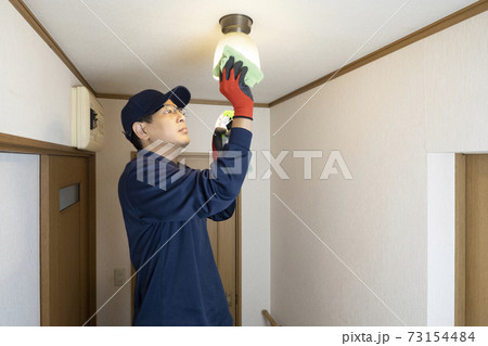 照明器具の掃除をするハウスクリーニング の男性作業員 73154484