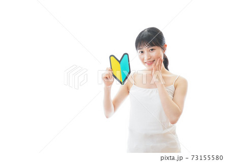 初心者マークを持つキャミソールをきた若い女性 初心者マークを持つキャミソールをきた若い女性 73155580