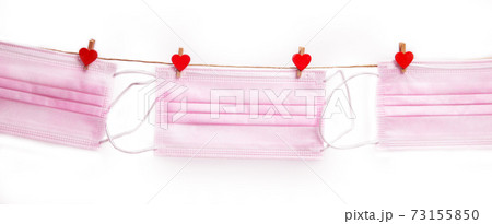 Pink protective medical mask hanging with clothes pegs in heart shape isolated on white background, Health, Covid-19 or Valentine's Day concept background Pink protective medical mask hanging with clothes pegs in heart shape isolated on white background, Health, Covid-19 or Valentine's Day concept background 73155850