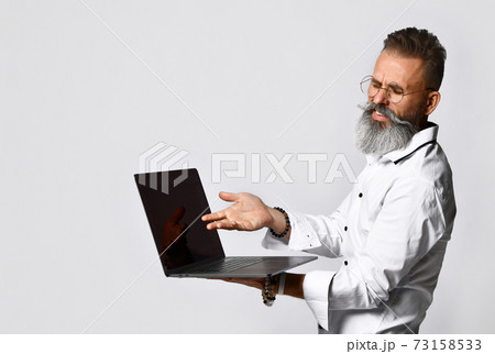 Stylish bearded hipster man in eyewear with laptop Stylish bearded hipster man in eyewear with laptop 73158533