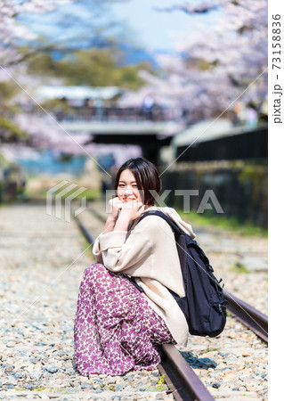 春の京都観光でインクラインの線路に座る女性の写真素材