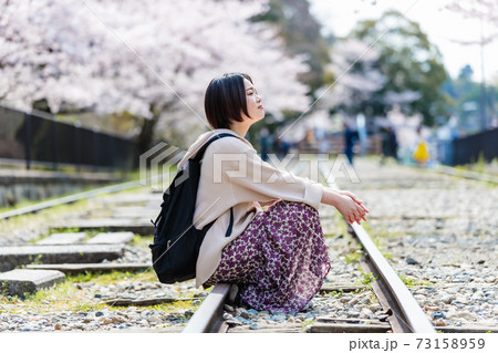 春の京都観光でインクラインの線路に座る女性の写真素材