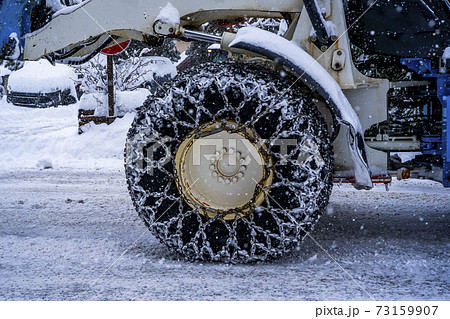 Closeup of a chained wheel of a snowy snow plow . Closeup of a chained wheel of a snowy snow plow . 73159907