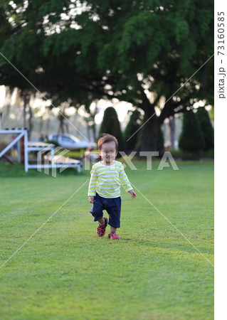 Asian boy is learning to walk in the garden. Asian boy is learning to walk in the garden. 73160585