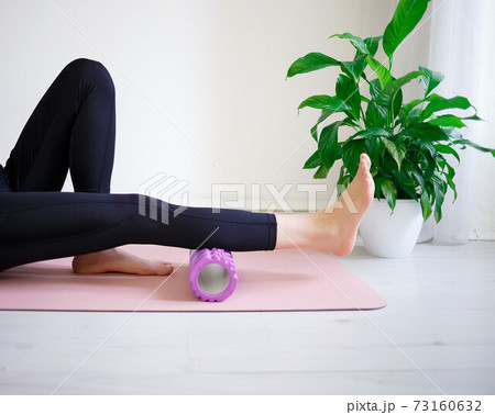 young woman doing exercises on a massage roller young woman doing exercises on a massage roller 73160632