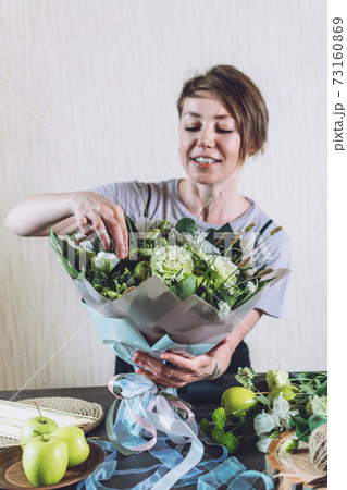 Flower Trends 2021, Naturalness, Flower Arranging, florist tricks, tips. Small business. Floral design studio, making decorations and arrangements. Florist woman make fruit edible bouquet 73160869