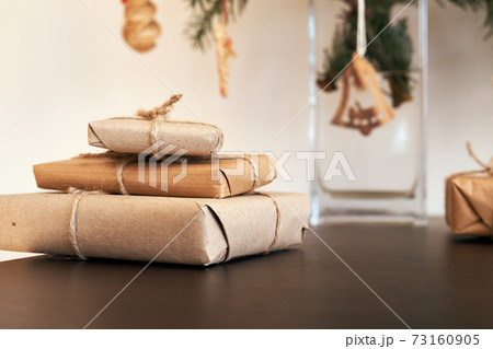Christmas presents wrapped in ecological recycled paper on a table Christmas presents wrapped in ecological recycled paper on a table 73160905