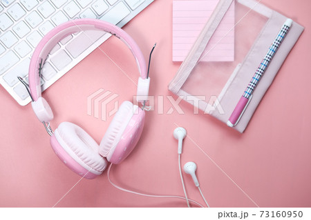 Top view of headphone on keyboard on pink . 73160950