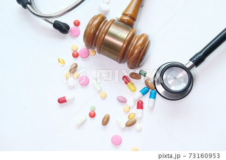 Top view of gavel, stethoscope and pills on white background 73160953