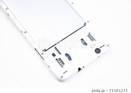 A cell phone with an open cover lies face down on a white background. A cell phone with an open cover lies face down on a white background. 73161272