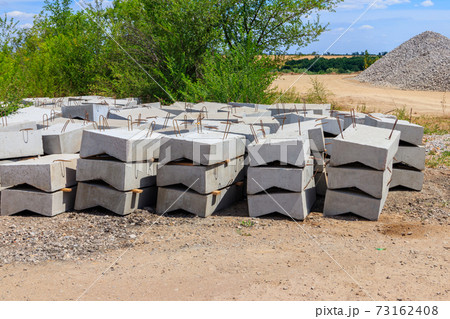 Stacks of the new concrete road curbs for road construction 73162408