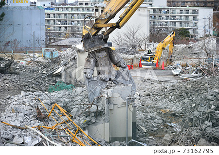 取り壊される老朽化した公営住宅 大型重機での解体の作業風景の写真素材