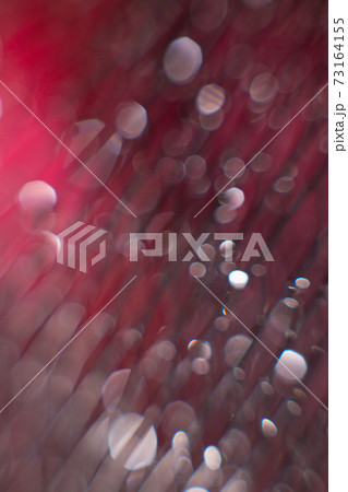 glare from water on a black mesh on a blurred red background. Abstract background glare from water on a black mesh on a blurred red background. Abstract background 73164155