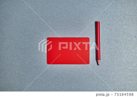 Flat lay with red card and red pencil on a gray background. Copy space 73164598