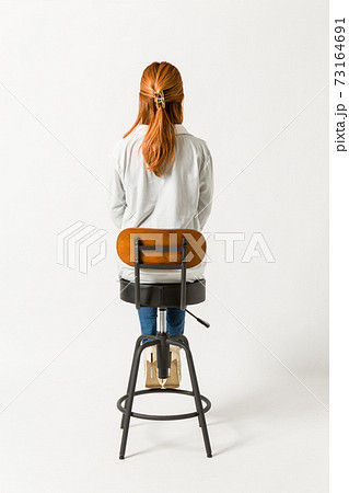 カウンターチェアに座る女性の後ろ姿の写真素材