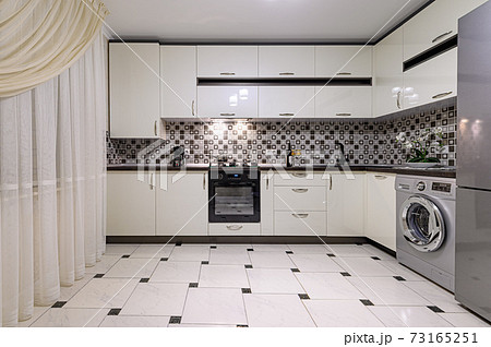 Brown and white modern kitchen interior Brown and white modern kitchen interior 73165251