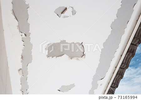 White color paint peeling off on ceiling house. Under the roof White color paint peeling off on ceiling house. Under the roof 73165994
