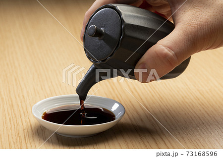 醤油を小皿に注ぎ入れる 醤油を小皿に注ぎ入れる 73168596
