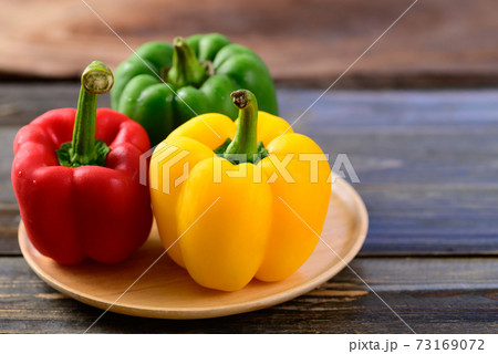 Fresh yellow, red and green bell peppers on wooden background, Organic vegetables Fresh yellow, red and green bell peppers on wooden background, Organic vegetables 73169072