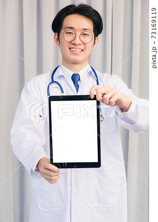 Doctor in uniform and stethoscope neck strap showing front blank screen smart digital tablet on hand Doctor in uniform and stethoscope neck strap showing front blank screen smart digital tablet on hand 73169119