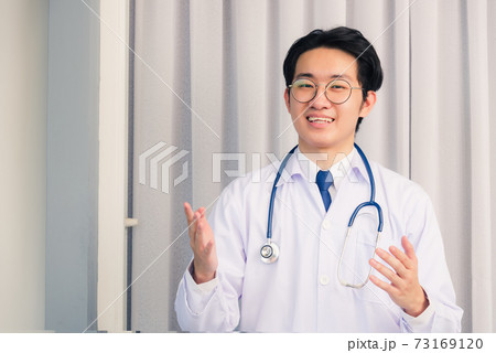 Doctor man smiling talking online video conference 73169120