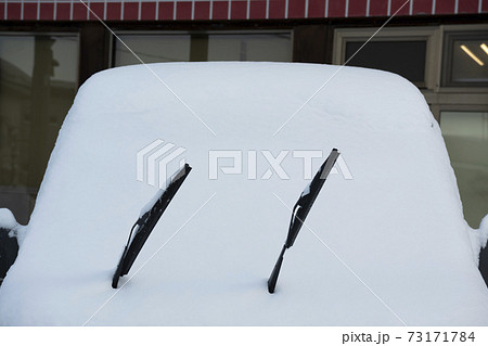 車に雪が積もってワイパーだけ出てる風景の写真素材