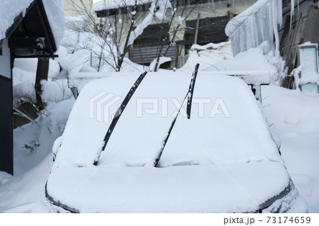 ワイパーがあがってる車に雪が積もってる風景の写真素材