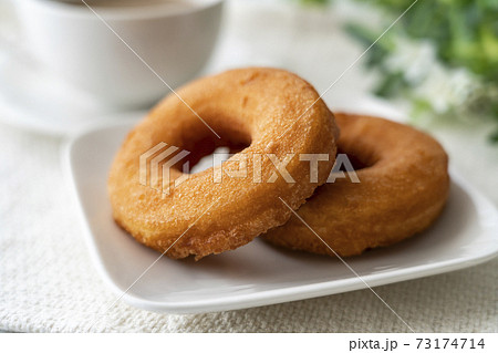 白いお皿にのったドーナツとミルクティーの写真素材