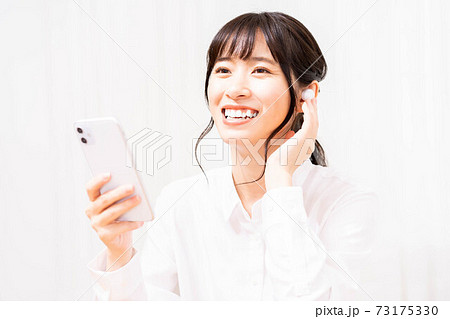 スマホで音楽を聴く若い女性 73175330