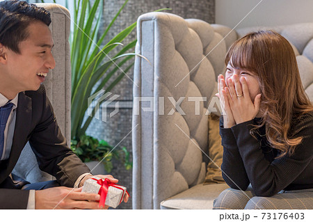 プレゼントをもらって喜ぶ女性 73176403
