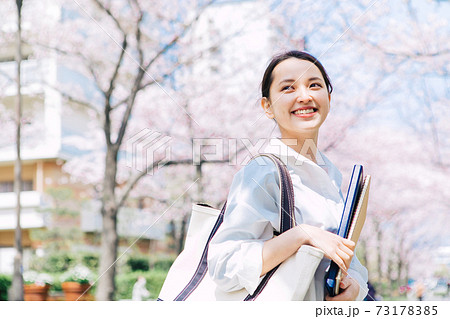桜並木のキャンパスを歩く女子大生 73178385