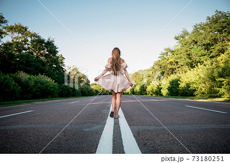 New way, new start, New year resolution, challenge, choice or change concept. Young Woman walking on the summer road with tree around 73180251