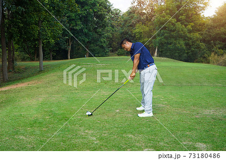 Golfer playing golf in the evening golf course, on sun set evening time. Man playing golf on a golf course in the sun. Golfer playing golf in the evening golf course, on sun set evening time. Man playing golf on a golf course in the sun. 73180486