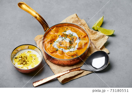 Murgh Makhani or Butter Chicken in copper bowl on gray concrete table top. Indian Cuisine dish Murgh Makhani or Butter Chicken in copper bowl on gray concrete table top. Indian Cuisine dish 73180551
