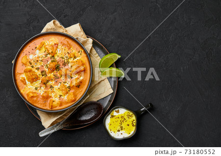 Murgh Makhani or Butter Chicken in black bowl on dark slate table top. Indian Cuisine dish  73180552