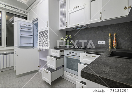 Open doors and drawers open at modern white kitchen 73181294