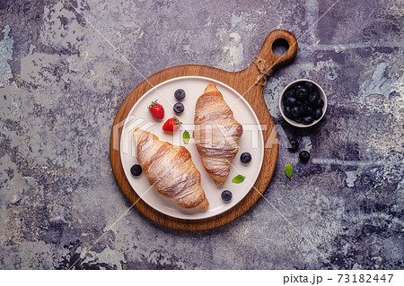 Breakfast with croissants and fresh fruits. 73182447