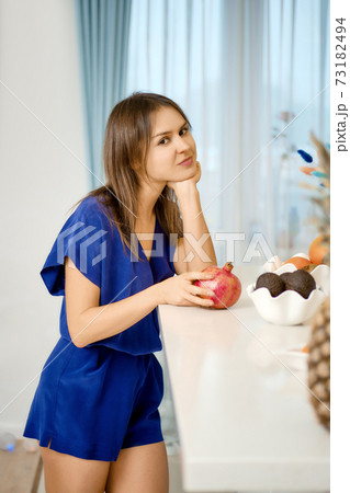 Beautiful young woman stands near kitchen tabletop 73182494
