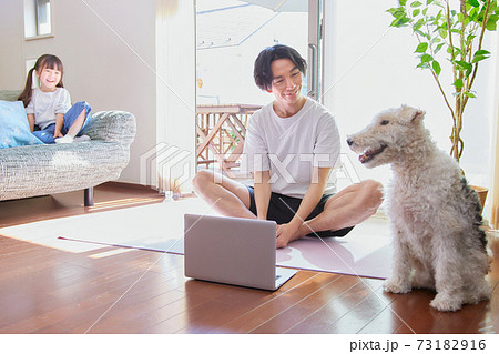 リビングでオンラインヨガをする若い男性 リビングでオンラインヨガをする若い男性 73182916