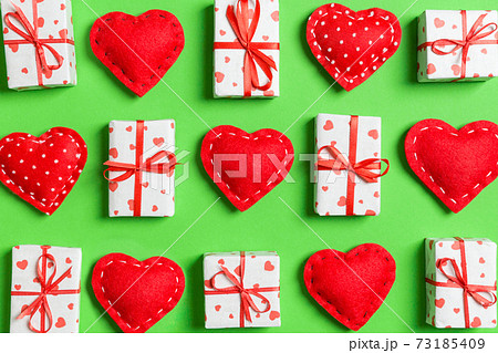 Composition of holiday white gift boxes and red textile hearts on colorful background. Valentine's day concept 73185409
